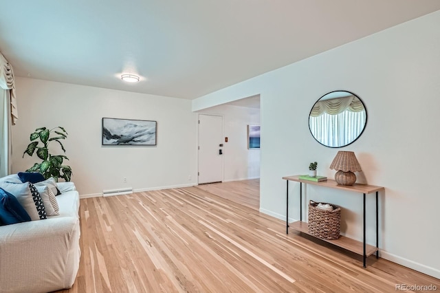366 Kenton St, Aurora, CO 80010 - living area featuring light wood-style floors and a baseboard heating unit