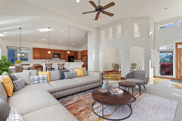 living room featuring ceiling fan and a high ceiling