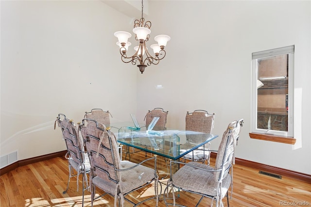 dining room with light hardwood / wood-style flooring and a notable chandelier