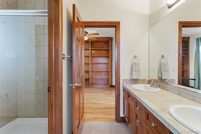 bathroom featuring vanity, tile patterned floors, and tiled shower