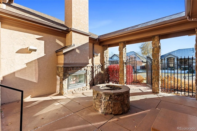 view of patio / terrace with an outdoor stone fireplace and a fire pit