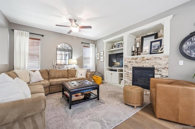 13463 Tamarac Pl, Thornton, CO 80602 - living area featuring wood finished floors, ceiling fan, a stone fireplace, and built in features