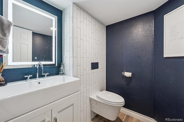 13463 Tamarac Pl, Thornton, CO 80602 - bathroom featuring a textured wall, wood finished floors, and vanity