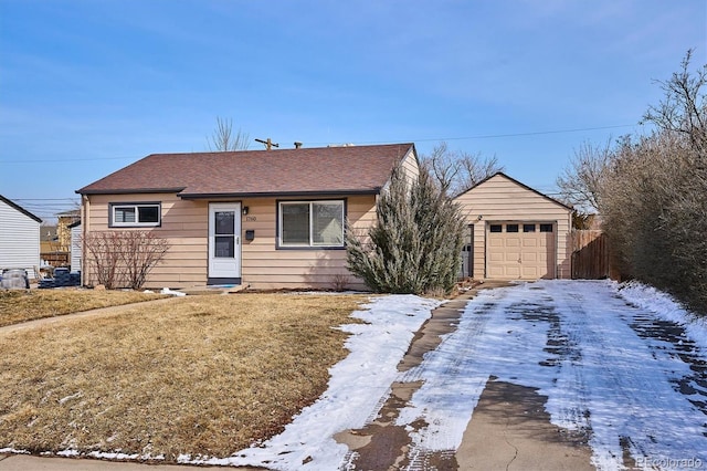 view of front facade featuring a garage, a yard, fence, and an outdoor structure