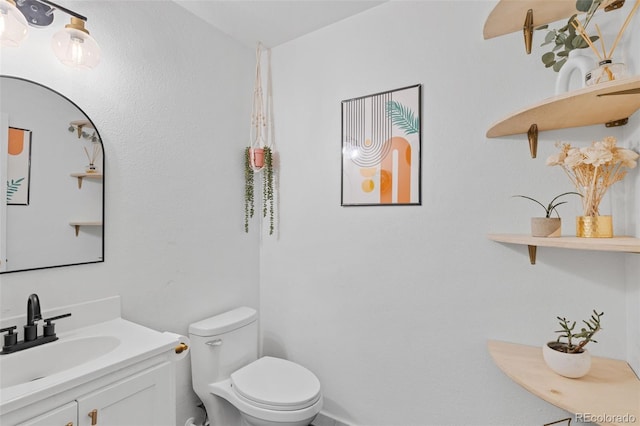 half bathroom featuring vanity and toilet