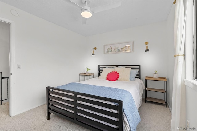 bedroom featuring baseboards, light carpet, and a ceiling fan