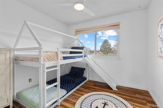 bedroom featuring a textured ceiling, baseboards, a ceiling fan, and wood finished floors