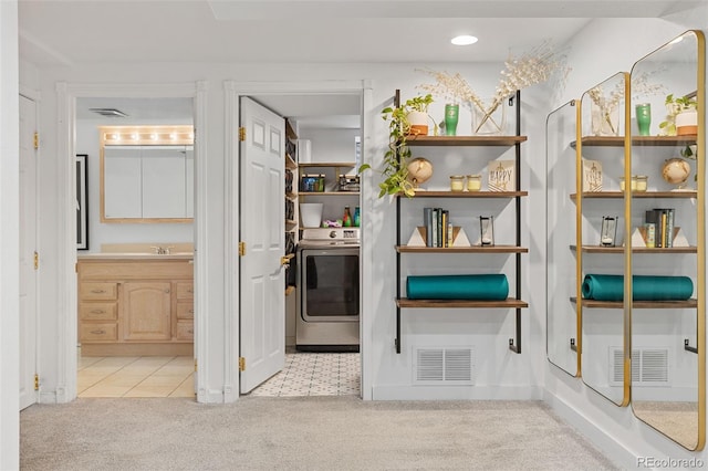 interior space featuring a sink, washer / clothes dryer, and visible vents