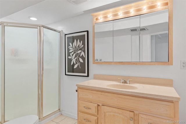 bathroom with vanity, tile patterned flooring, a shower stall, and toilet