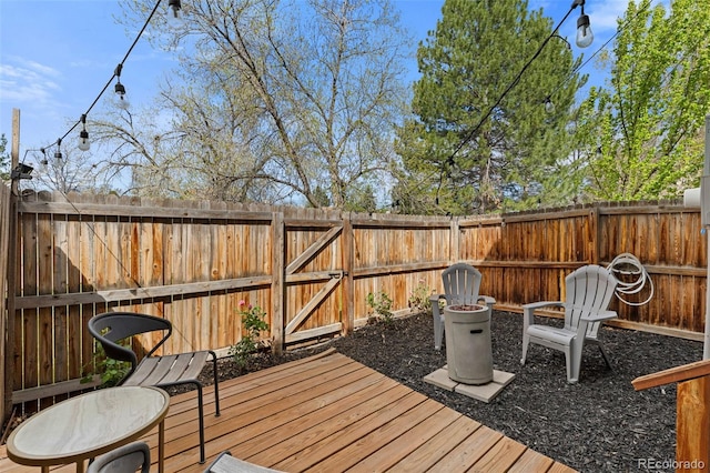 deck featuring a fenced backyard and a gate
