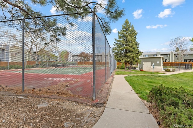 view of home's community with a tennis court and fence