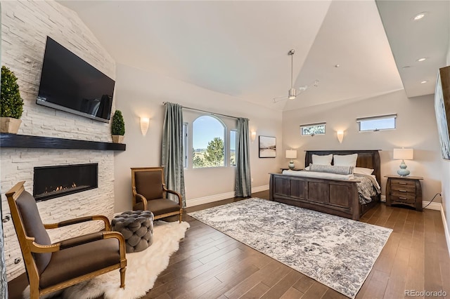 bedroom with dark hardwood / wood-style flooring, a fireplace, and high vaulted ceiling