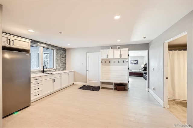 mudroom with sink and light hardwood / wood-style flooring