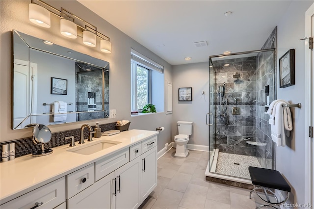 bathroom with vanity, a shower with shower door, tile patterned floors, and toilet