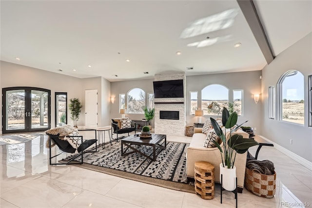 living room featuring a healthy amount of sunlight, a fireplace, and french doors