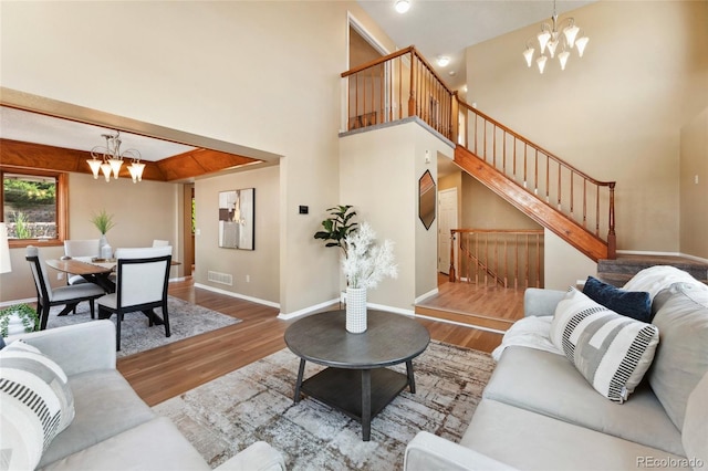 11932 W 56th Cir, Arvada, CO 80002 - living area with a chandelier, wood finished floors, stairs, and a high ceiling