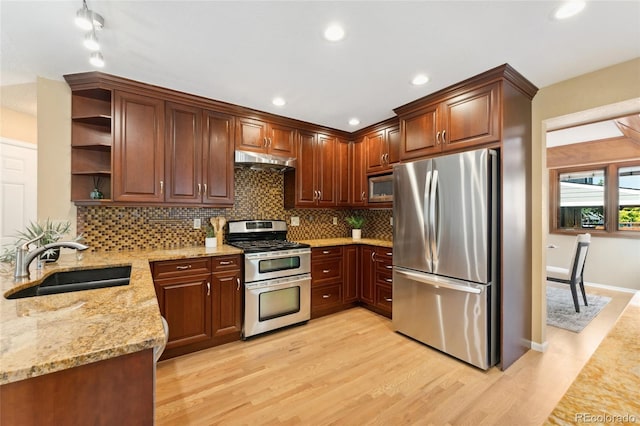 11932 W 56th Cir, Arvada, CO 80002 - kitchen featuring stainless steel appliances, open shelves, under cabinet range hood, light stone counters, and light wood finished floors