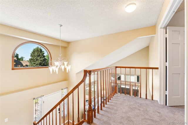 11932 W 56th Cir, Arvada, CO 80002 - staircase featuring carpet flooring, a textured ceiling, and a chandelier