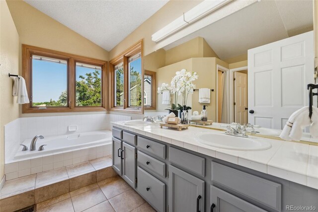 11932 W 56th Cir, Arvada, CO 80002 - full bath with lofted ceiling, double vanity, a bath, healthy amount of natural light, and tile patterned floors