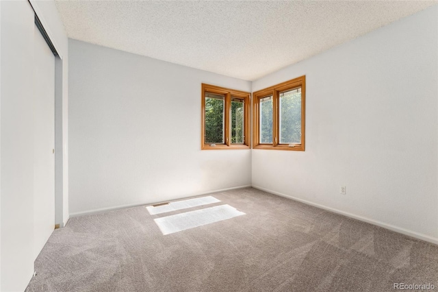 11932 W 56th Cir, Arvada, CO 80002 - unfurnished bedroom featuring carpet flooring, a textured ceiling, and a closet