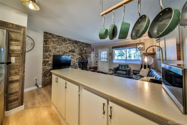 466 Hi Country Dr Unit 109, Winter Park, CO 80482 - kitchen with light wood-style floors, white cabinetry, open floor plan, and light countertops