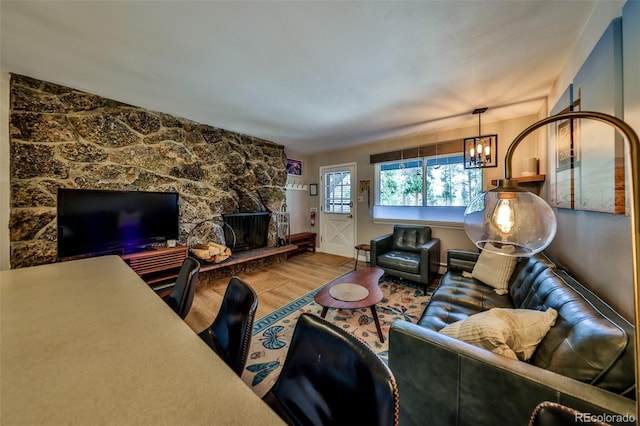 466 Hi Country Dr Unit 109, Winter Park, CO 80482 - living room featuring wood finished floors, a chandelier, and a stone fireplace