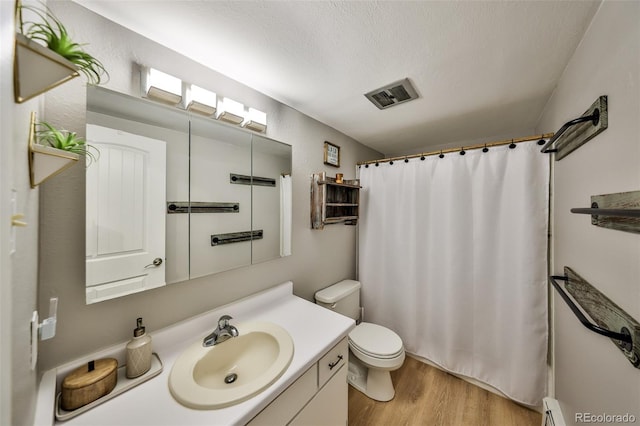 466 Hi Country Dr Unit 109, Winter Park, CO 80482 - bathroom featuring vanity, wood finished floors, a textured ceiling, a shower with shower curtain, and a baseboard heating unit