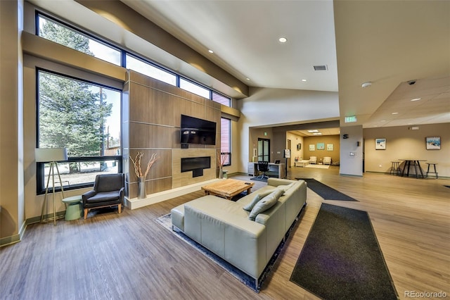 466 Hi Country Dr Unit 109, Winter Park, CO 80482 - living area with wood finished floors, recessed lighting, a glass covered fireplace, plenty of natural light, and a towering ceiling