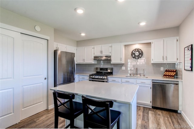 kitchen with white cabinetry, sink, hardwood / wood-style floors, and appliances with stainless steel finishes