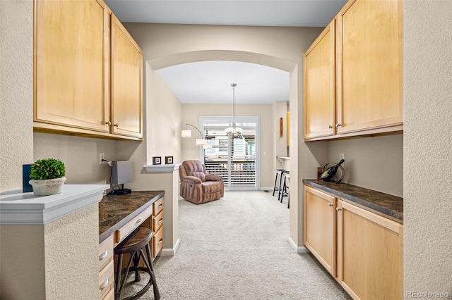 interior space with arched walkways, light carpet, baseboards, and an inviting chandelier