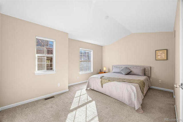 bedroom featuring lofted ceiling, carpet floors, visible vents, and baseboards