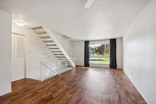 interior space with a textured ceiling and dark hardwood / wood-style flooring