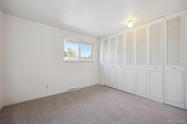 unfurnished bedroom featuring light carpet