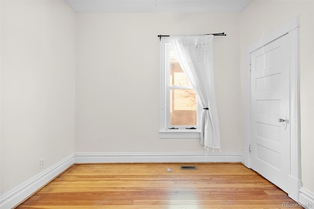 spare room featuring visible vents, baseboards, and light wood-style floors