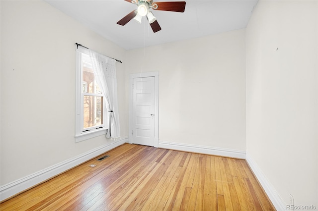 empty room with visible vents, baseboards, a ceiling fan, and light wood finished floors