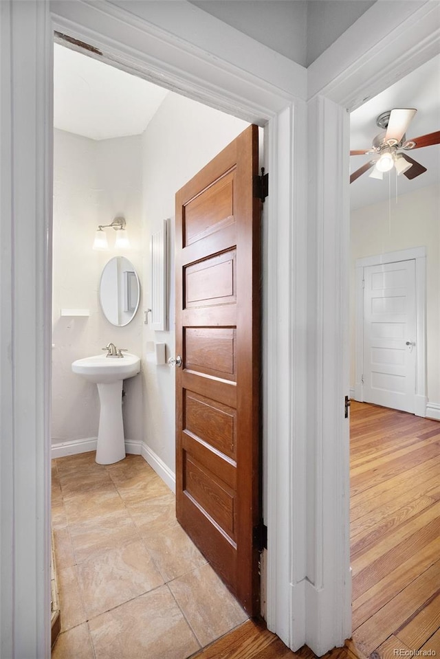 bathroom featuring a ceiling fan and baseboards