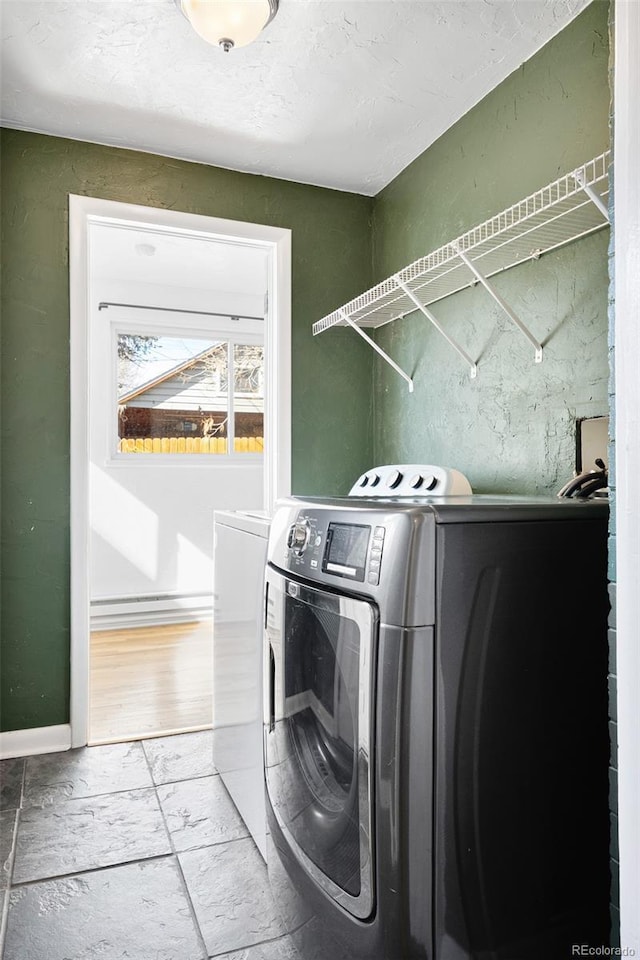 washroom featuring washer and clothes dryer, laundry area, and baseboards