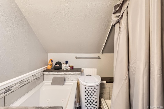 72 Hilltop Dr, Bailey, CO 80421 - full bath with radiator, a jetted tub, and lofted ceiling