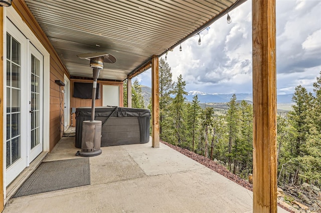 72 Hilltop Dr, Bailey, CO 80421 - view of patio with a hot tub, a mountain view, a view of trees, and french doors