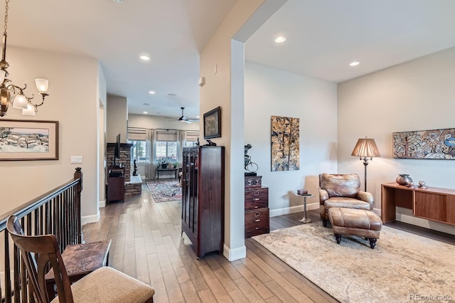 interior space with baseboards, light wood-type flooring, arched walkways, and recessed lighting