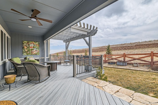 wooden deck featuring ceiling fan, fence, and a pergola