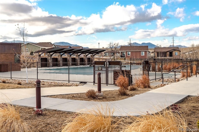 view of property's community featuring a residential view, fence, and a swimming pool