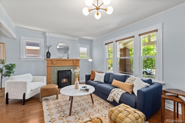 3332 N Vine St, Denver, CO 80205 - living room featuring a chandelier, ornamental molding, wood finished floors, and a tiled fireplace