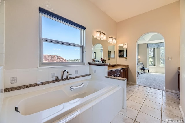 full bathroom featuring a bath, baseboards, vanity, and tile patterned floors