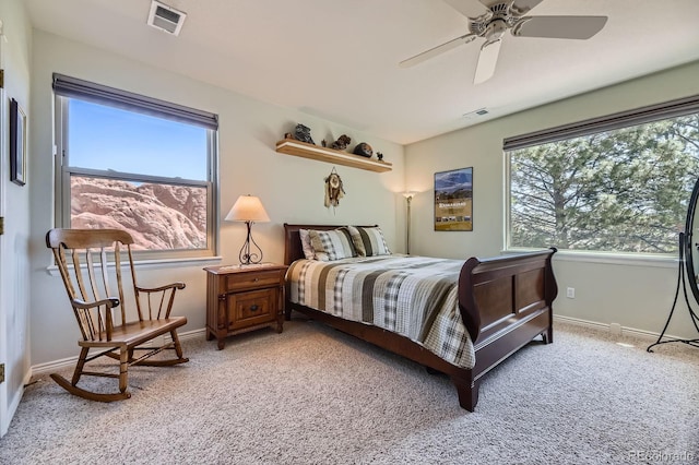 bedroom with baseboards, visible vents, and light colored carpet