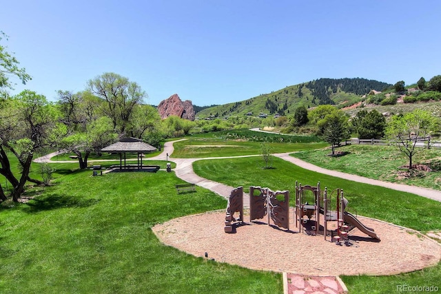 surrounding community with a gazebo, playground community, a yard, and a mountain view