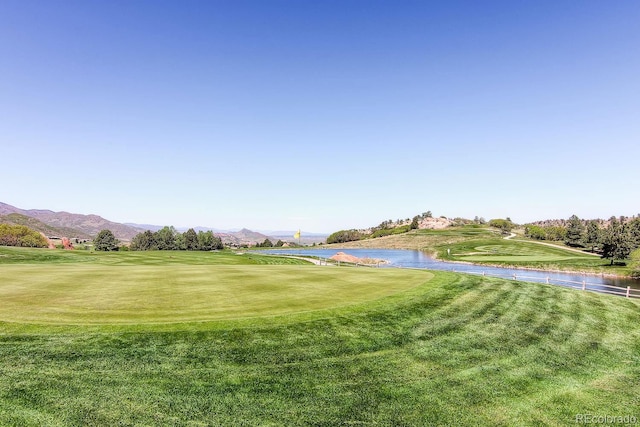 view of yard featuring view of golf course and a water and mountain view