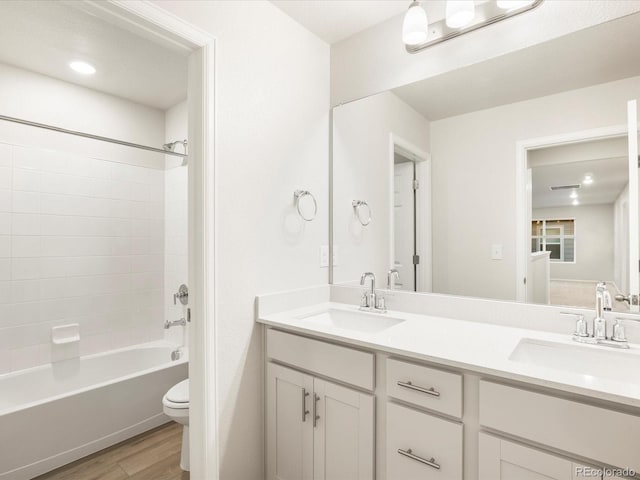 full bathroom with vanity, hardwood / wood-style floors,  shower combination, and toilet