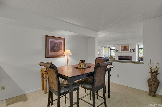 7000 E Quincy Ave Unit 302, Denver, CO 80237 - dining space with a textured ceiling, a fireplace, light colored carpet, and baseboards