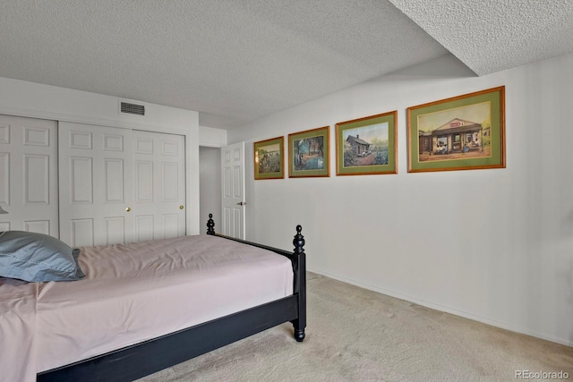 7000 E Quincy Ave Unit 302, Denver, CO 80237 - bedroom featuring a textured ceiling, light carpet, a closet, and baseboards